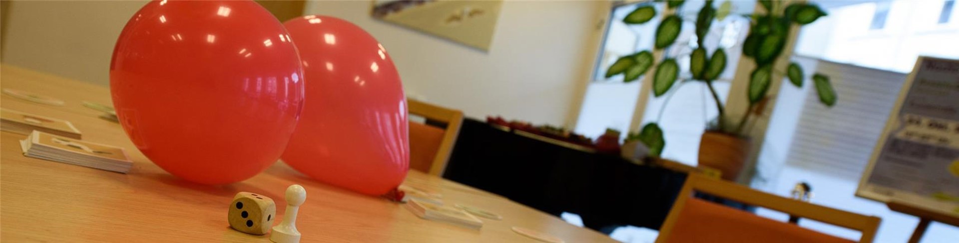 Auf dem Tisch liegen Ballons und ein Legespiel